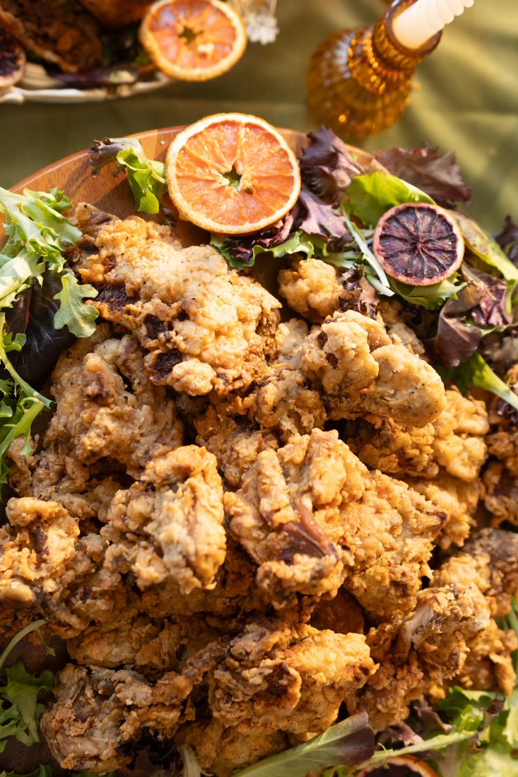 Crispy fried oyster mushrooms plated with greens and citrus